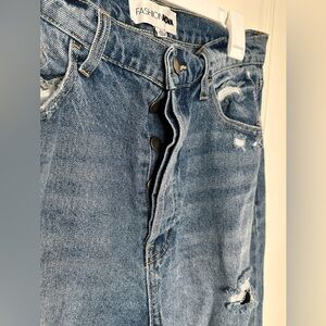 Wide leg, high waist denim jeans with holes and rips. Buttons instead of zipper